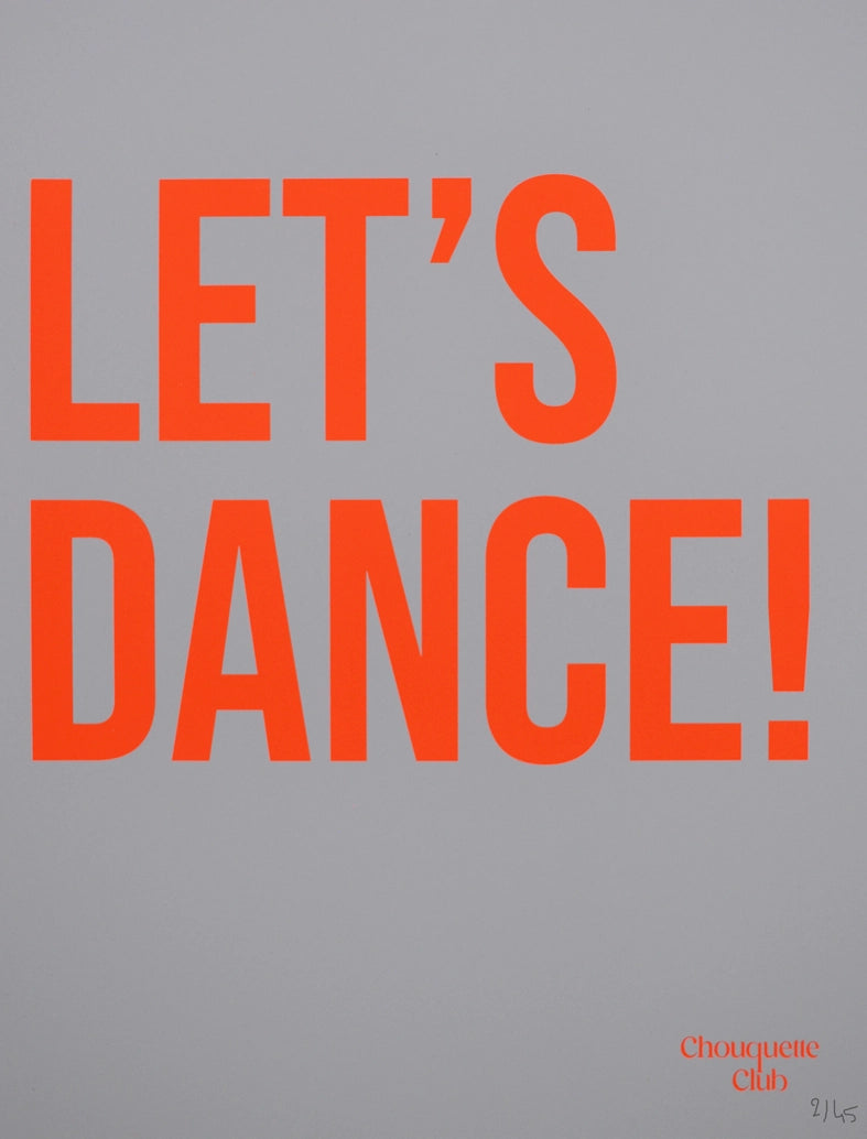 photo dans un salon avec une affiche sérigraphiée marquée let's dance en orange fluo sur un fond blanc dans un cadre doré
