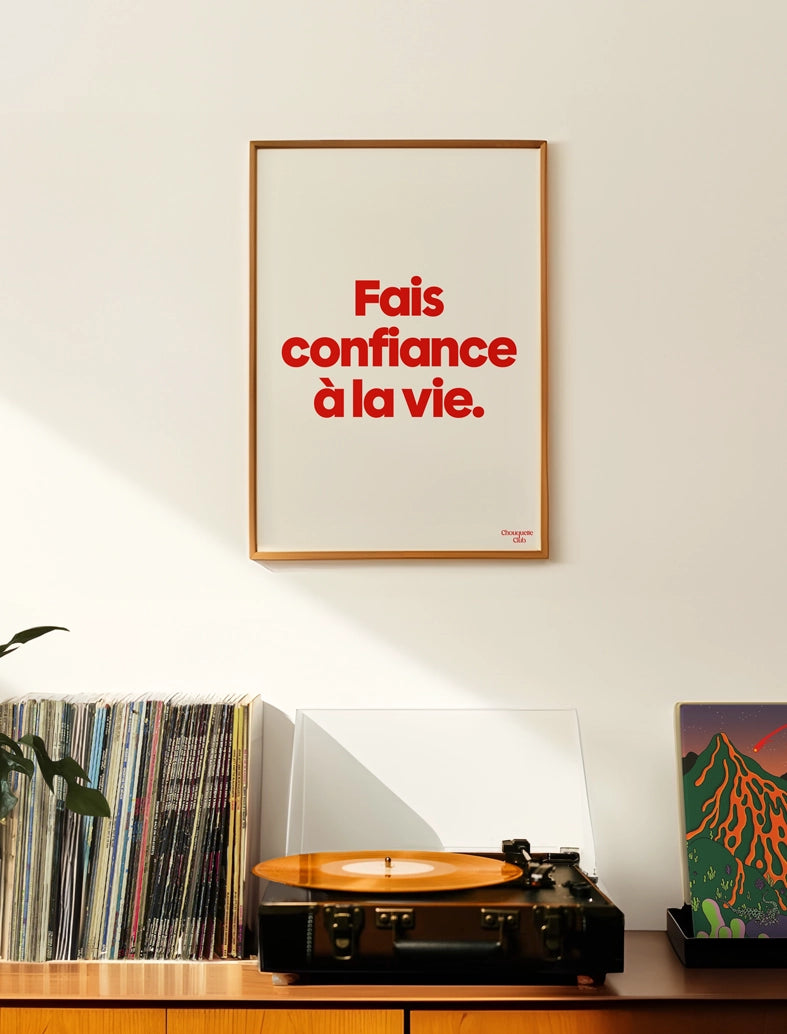 Fais confiance à la vie affiche (rouge et blanc) encadré dans un salon avec une platine vinyl