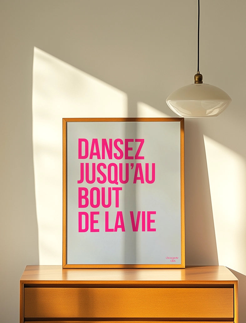 Dansez jusqu'au bout de la vie affiche(rose fluo et blanc) affiche encadré posé sur un meuble de la marque Chouquette Club