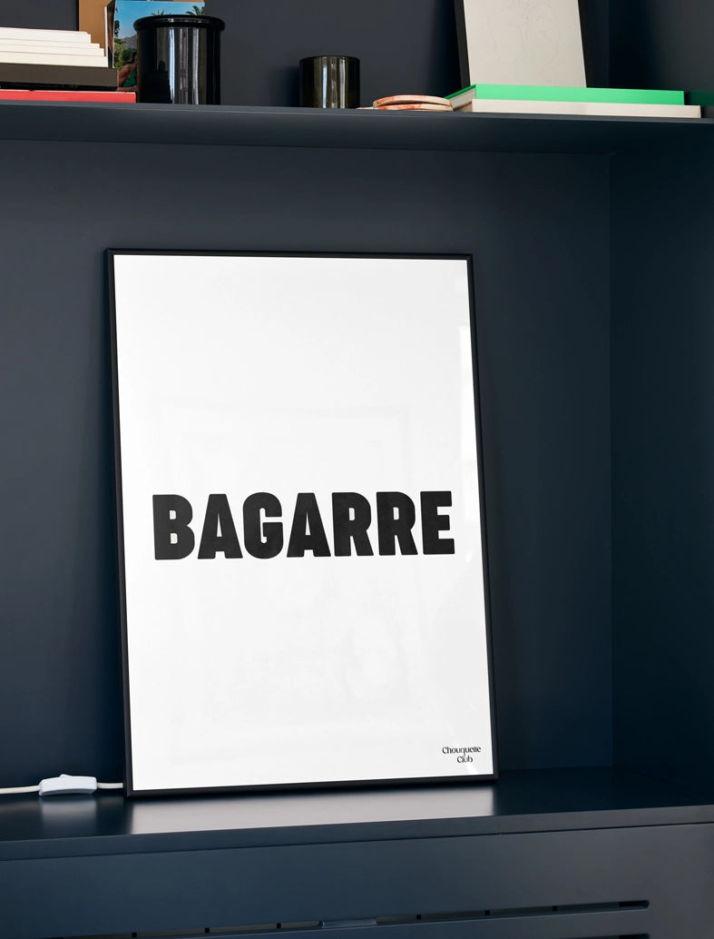 cadre noir avec affiche "bagarre" écrit en noir et blanc sur mur noir