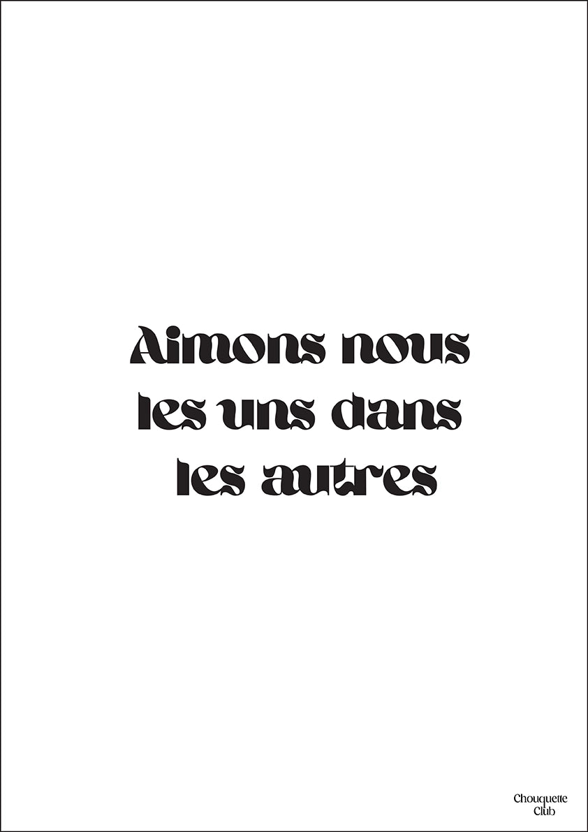 une carte postale blanche avec écriture en noir dessus “Aimons nous les uns dans les autres”.