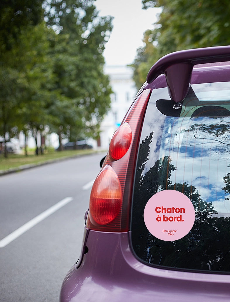 Sticker « Chaton à bord » rose et rouge collé sur une voiture