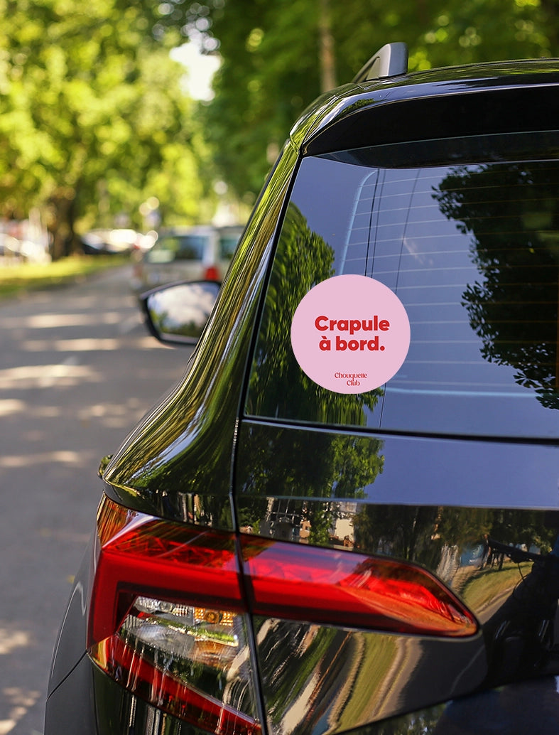 Sticker « Crapule à bord » rose et rouge collé sur une voiture