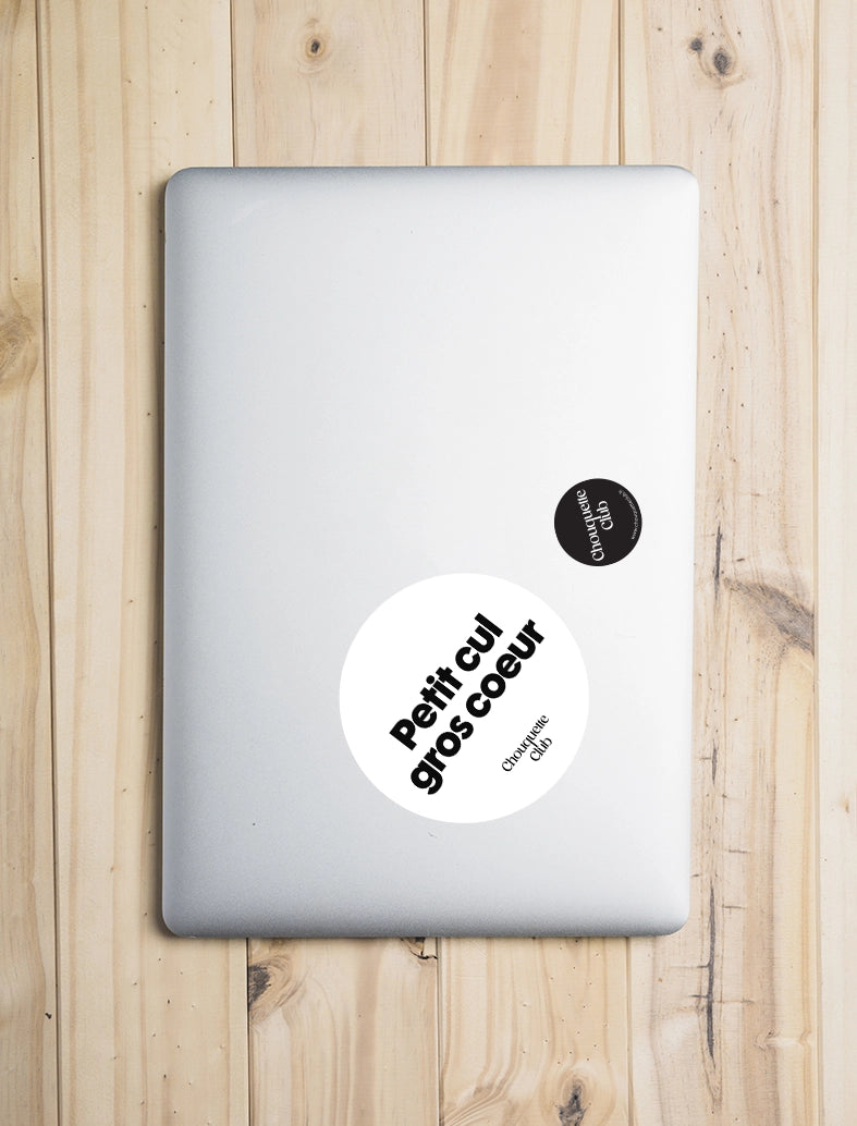 Sticker « Petit cul, gros coeur » blanc et noir collé sur un laptop