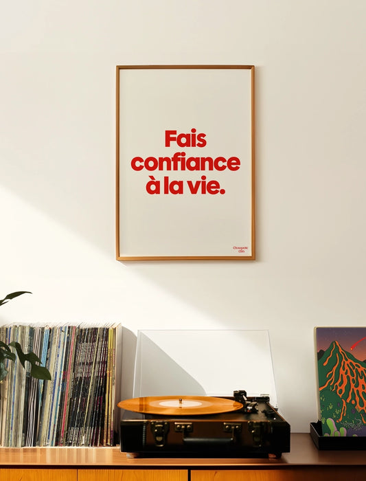 Fais confiance à la vie affiche (rouge et blanc) encadré dans un salon avec une platine vinyl