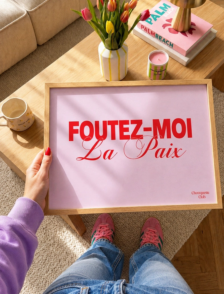 Foutez-moi la paix affiche rose et rouge dans les mains d'une fille qui la tient dans ses mains