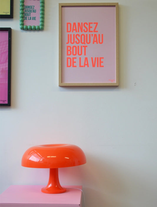 Mur avec l'affiche Dansez jusqu'au bout de la vie  (orange fluo et rose) et d'autres cadres