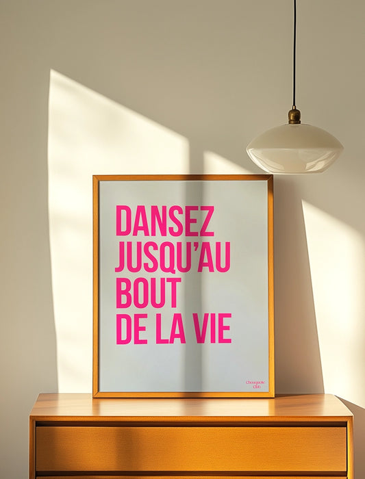 Dansez jusqu'au bout de la vie affiche(rose fluo et blanc) affiche encadré posé sur un meuble de la marque Chouquette Club