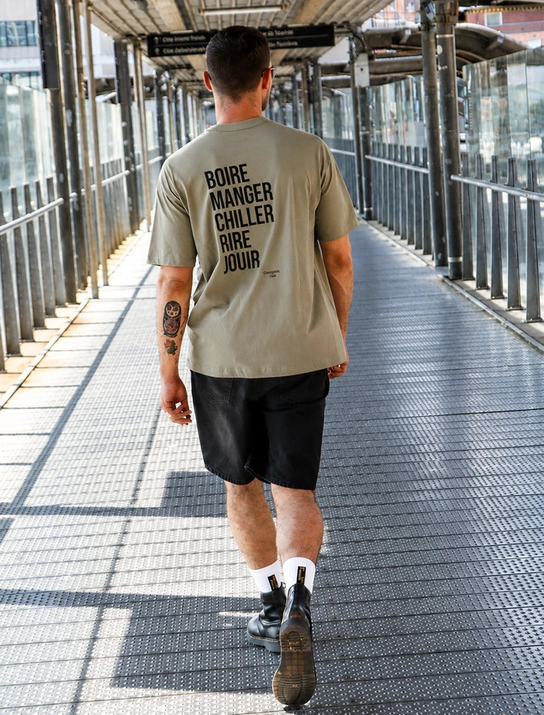 Tee-shirt homme "Boire manger chiller rire jouir" kaki porté par un homme brun