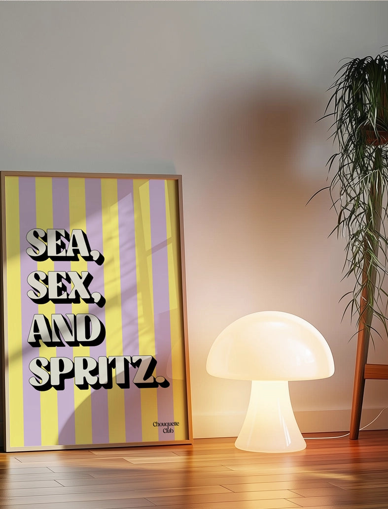 Affiche Sea, sex and spritz parme et jaune posé au sol sur du parquet