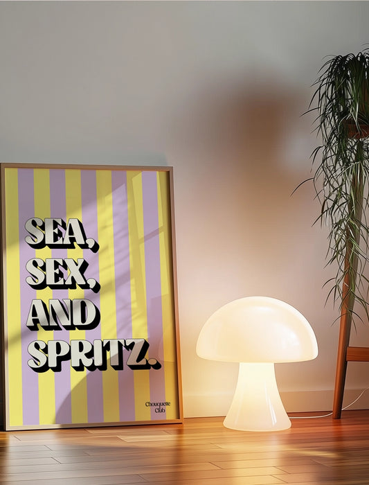 Affiche Sea, sex and spritz parme et jaune posé au sol sur du parquet