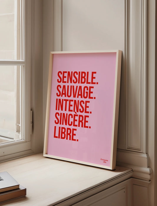Sensible et sauvage affiche (rose et rouge) encadré posé sur un rebord de fenêtre